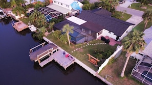 Une maison avec un quai, une piscine et un patio couvert.