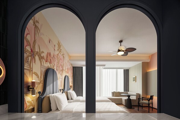Habitación de hotel con cama, escritorio, silla, ventilador de techo y ventana grande.