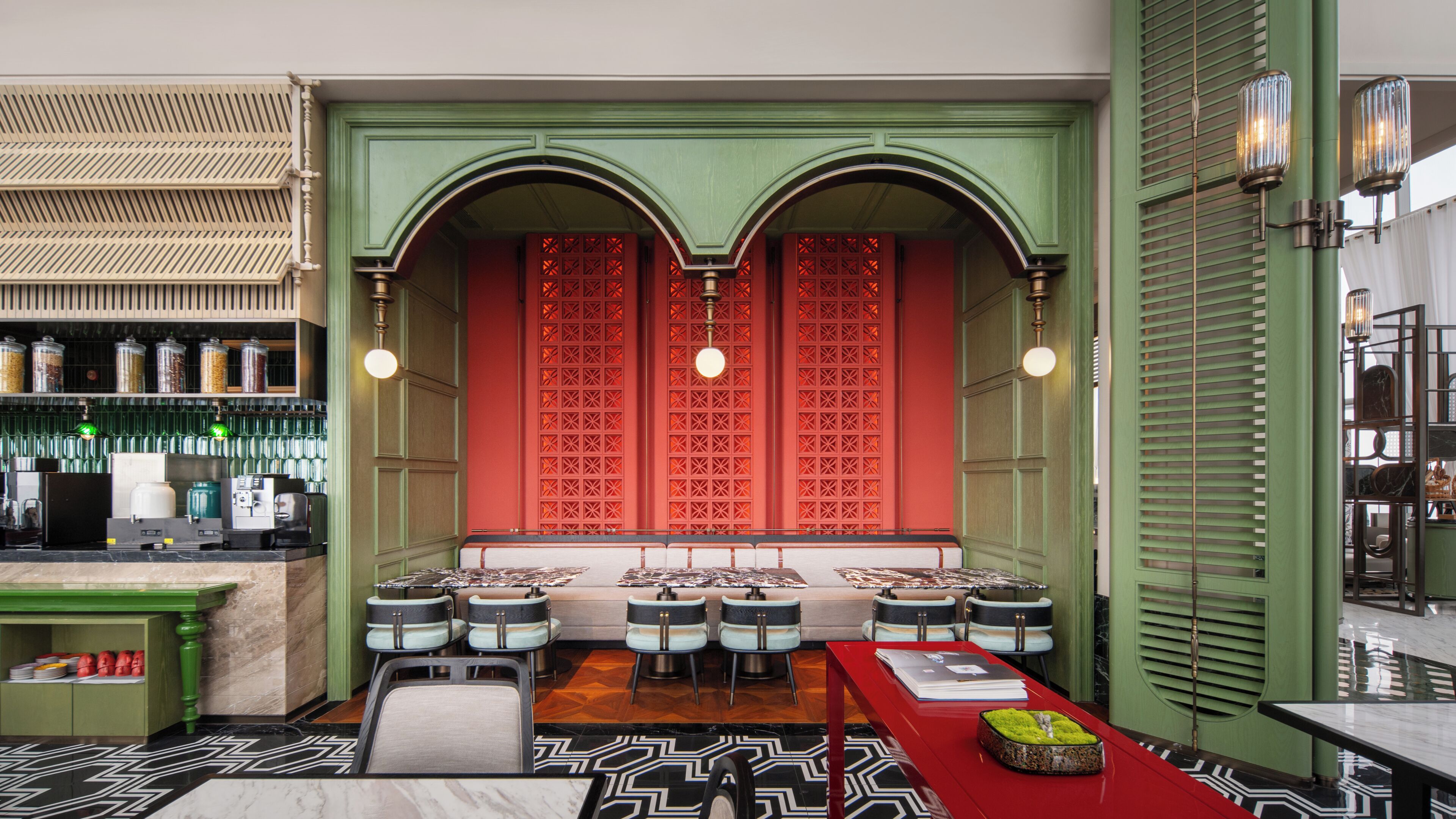 A restaurant with a green and red color scheme, a bar area, and a seating arrangement with tables and chairs.