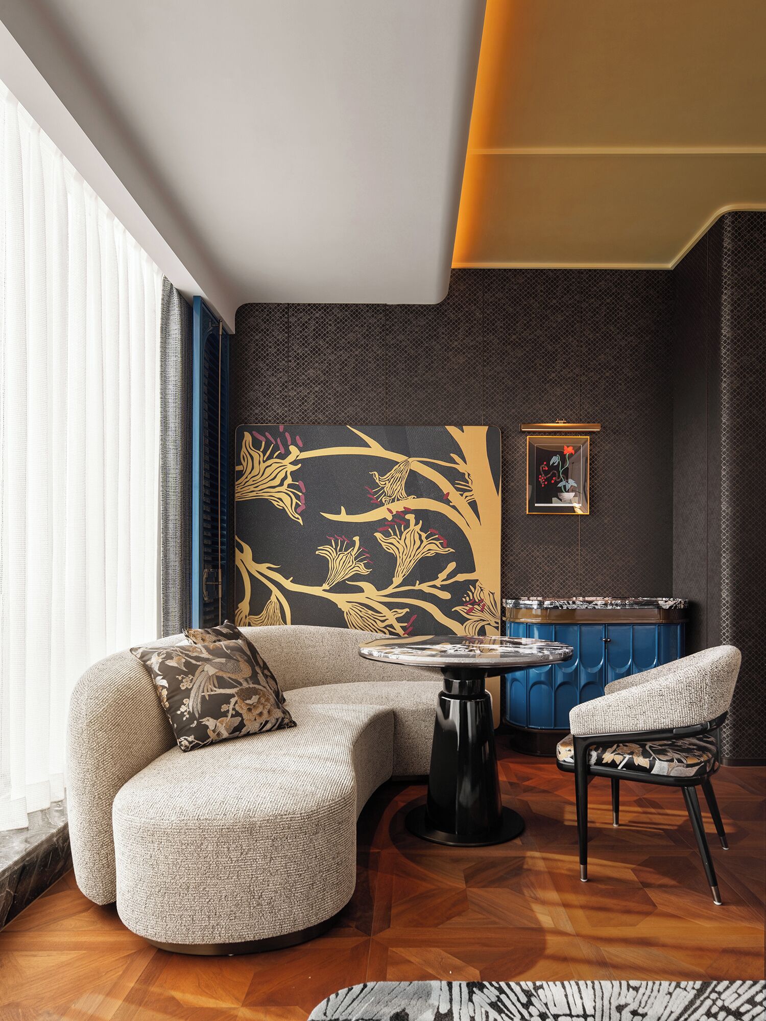 Un salon moderne avec un canapé aux lignes courbes, une table basse ronde et un fauteuil bleu qui apporte une touche de couleur.