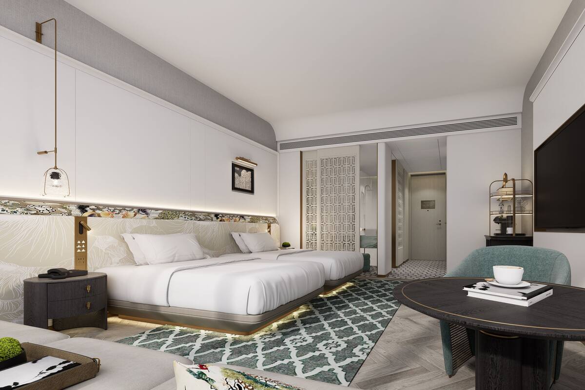 Ein modernes Hotelzimmer mit Bett, Nachttisch und rundem Tisch mit Buch und Tasse.