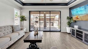 Un vaste espace de vie comprenant un canapé, une table basse et un ventilateur de plafond.