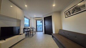 Appartement, balcon, vue sur la ville | Aire de séjour | Téléviseur à écran plat