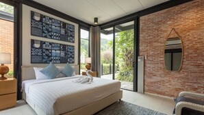 Een moderne slaapkamer met een groot bed, een bakstenen muur en uitzicht op groen.