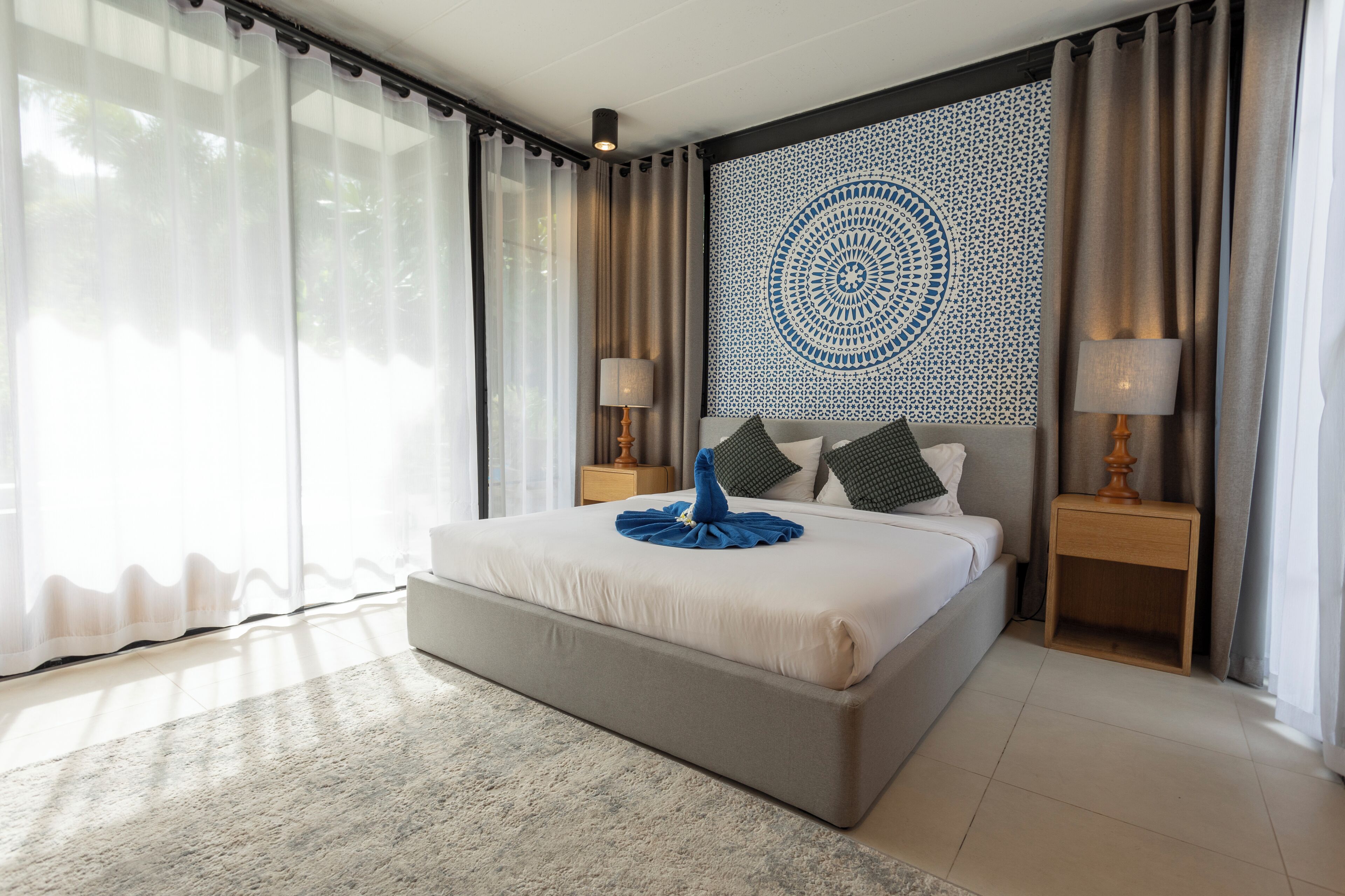 Une chambre d’hôtel moderne avec un grand lit, un mur décoratif et une vue sur l’extérieur.