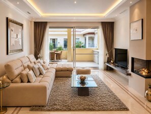 A modern living room with a sofa, a coffee table, a TV, and a fireplace.