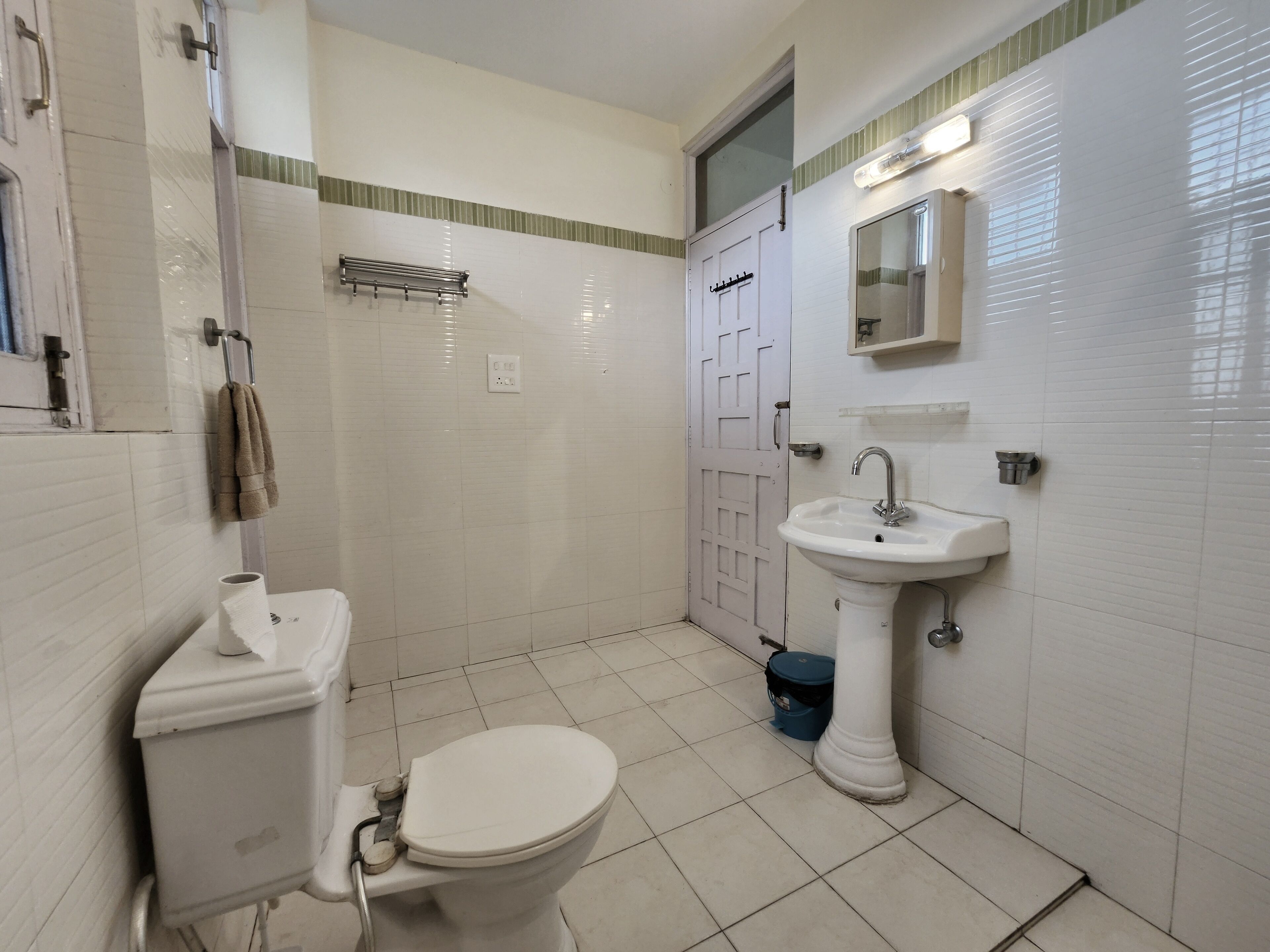 Egy fürdőszoba, amelyben WC, mosdókagyló és zuhanyzó található.