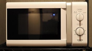 A white microwave oven with a digital display and control knobs.