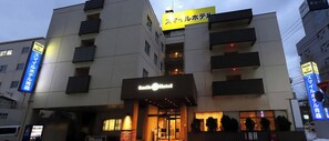 A hotel with a sign reading "Smile Hotel" and multiple signs in Japanese.