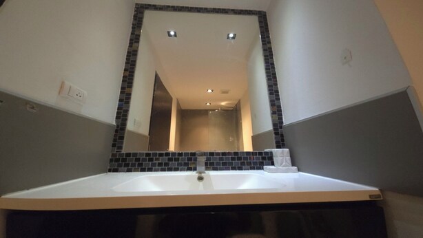 A bathroom with a white sink, a mirror with a black frame, and a tiled backsplash. - The Chalong Pearl 1BR  T1-703 (Chalong)