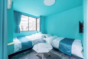 A room with teal walls, two beds, a small white table, and a window with curtains. - R905442_Apt / Shibuya-ku Tokyo (Shibuya-ku)