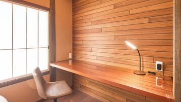 Una habitación moderna con pared de madera, un escritorio, una silla y una ventana.