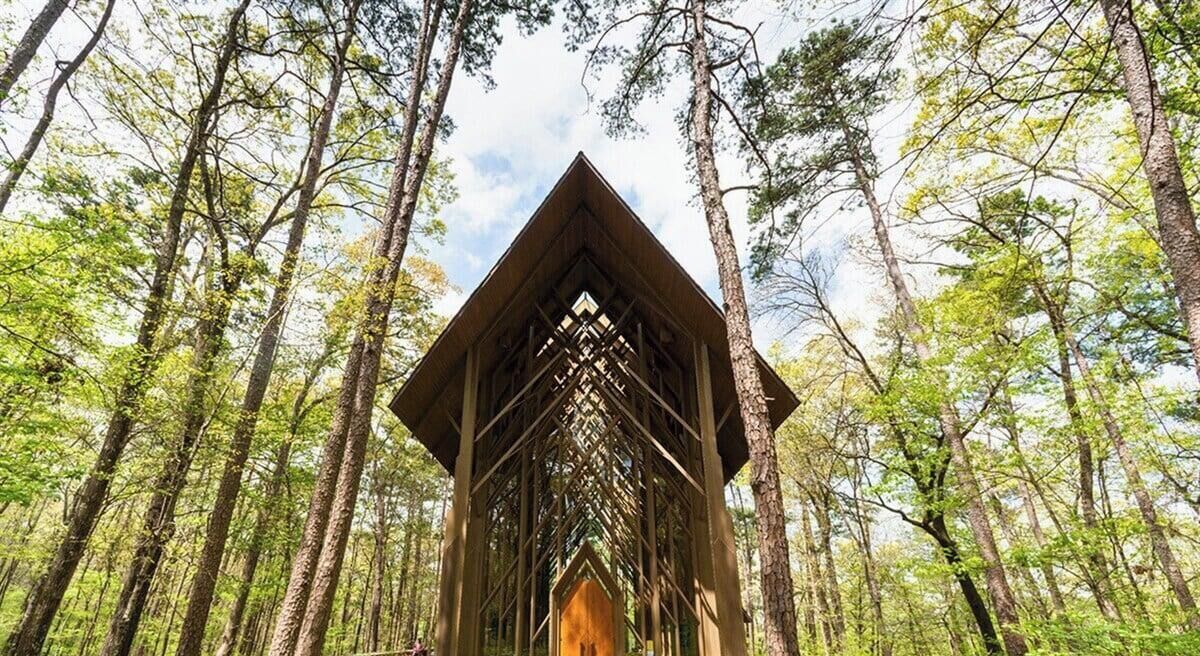 A wooden structure in a forest with tall trees.