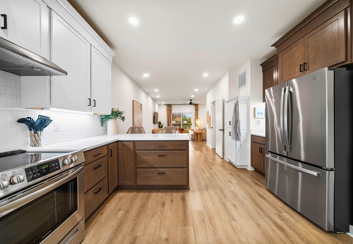 A modern kitchen with wooden cabinets, stainless steel appliances, and a central island.