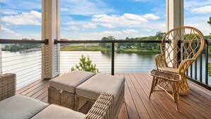 A covered deck with wicker furniture, a view of a lake, and a chair. - Side-by-Side Lake Hamilton Homes w/Dock, Pool (Hot Springs)