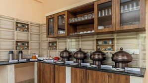 A kitchen with wooden cabinets, a black countertop, and various kitchenware. - Treebo Arabica Valley-Coffee Plantation Retreat (Chikkamagaluru)