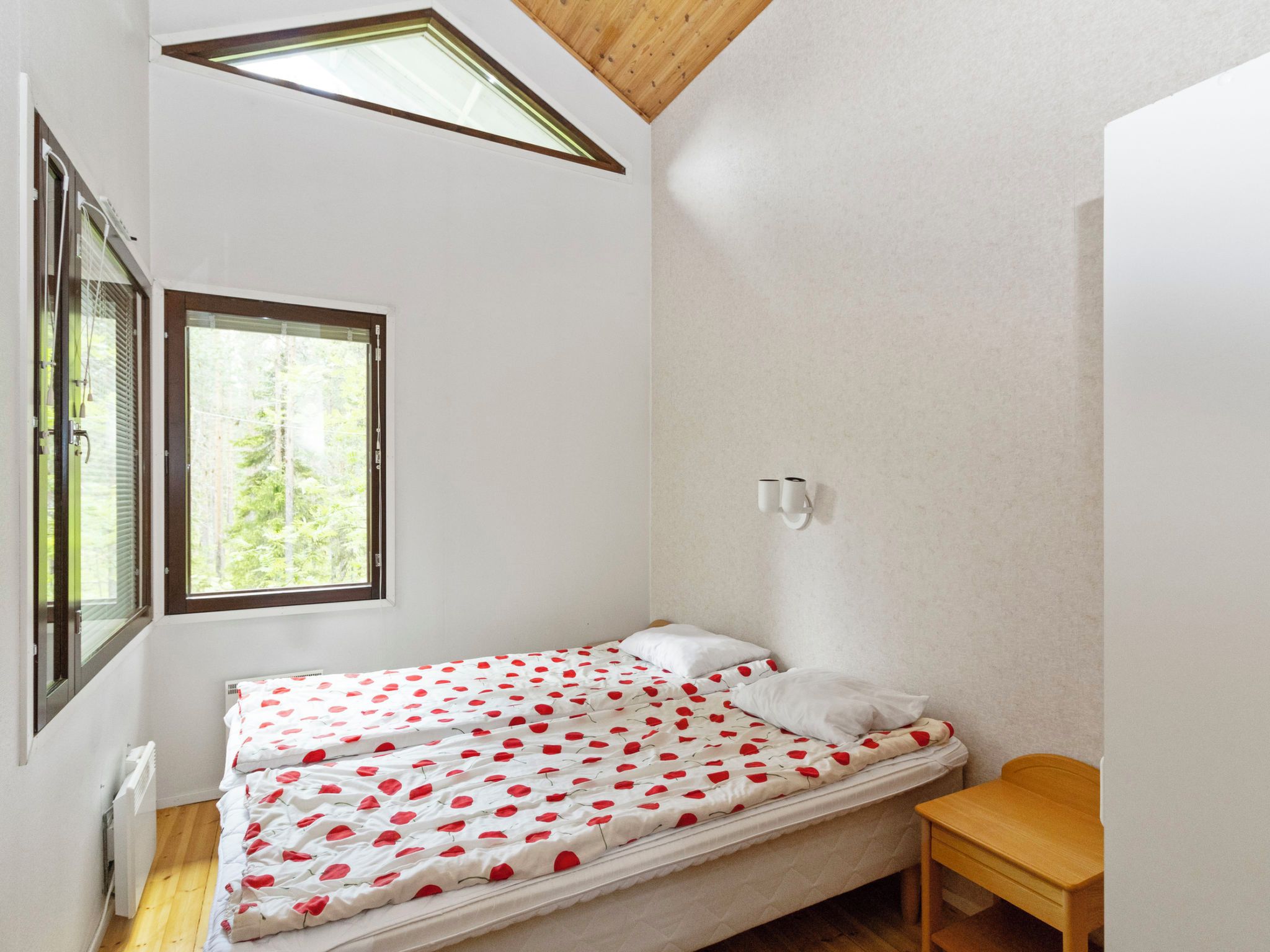 Une petite chambre avec un lit simple, une fenêtre et un puits de lumière.