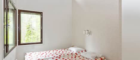 Ein kleines Schlafzimmer mit einem Einzelbett, einem Fenster und einem Dachfenster.