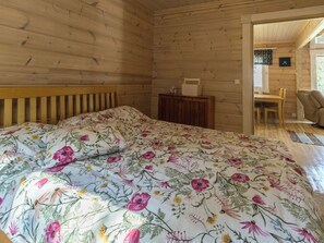 L’intérieur d’un chalet en bois comprend un lit, une petite table et un coin repas.