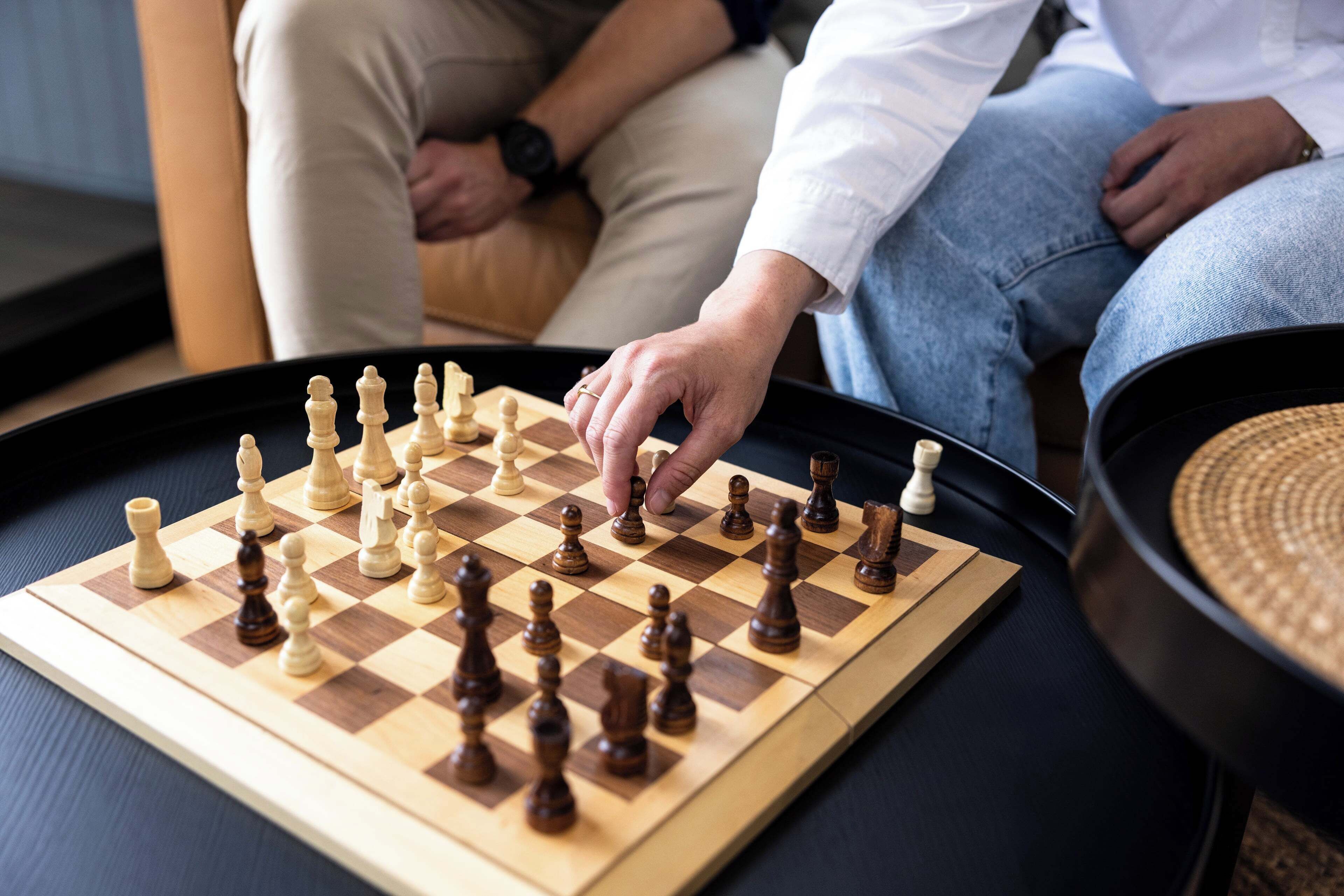 A chessboard on a table with a person playing.