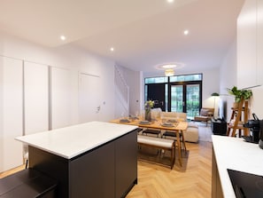 Eine moderne Küche mit Essbereich, Holzboden und Blick ins Freie.