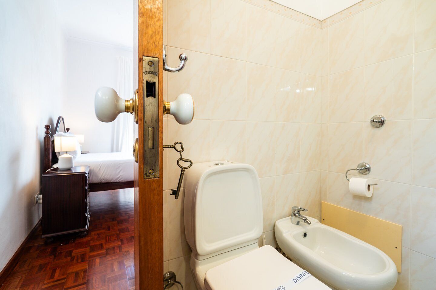 A hotel bathroom with a toilet, bidet, and sink.