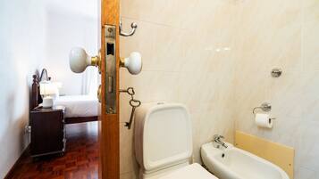 A hotel bathroom with a toilet, bidet, and sink.