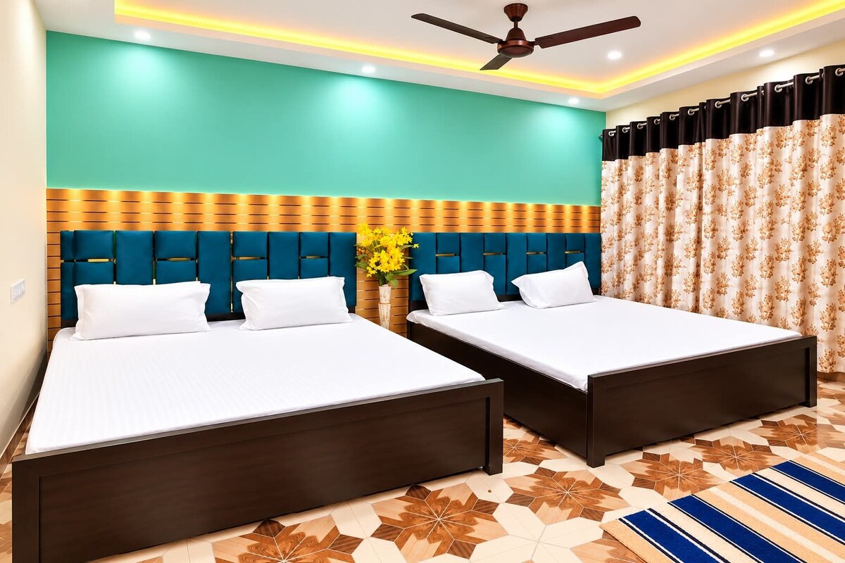 Ein Hotelzimmer mit zwei Betten, einem Deckenventilator und einem gemusterten Boden.