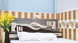 Ein Schlafzimmer mit einem Bett, einer Blumenvase und einer Wand mit Muster.