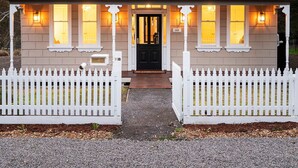 A two-story house with a gabled roof, a front porch with white picket fencing, and a mailbox labeled "14B". - Hilltop Victorian Retreat - Firepit + Sunset views (Castlemaine)