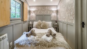 Un dormitorio con una cama grande, una ventana, una mesita de noche y una pared con diseños elaborados.
