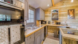 Una cocina moderna con electrodomésticos de acero inoxidable, armarios de madera y techo de madera.