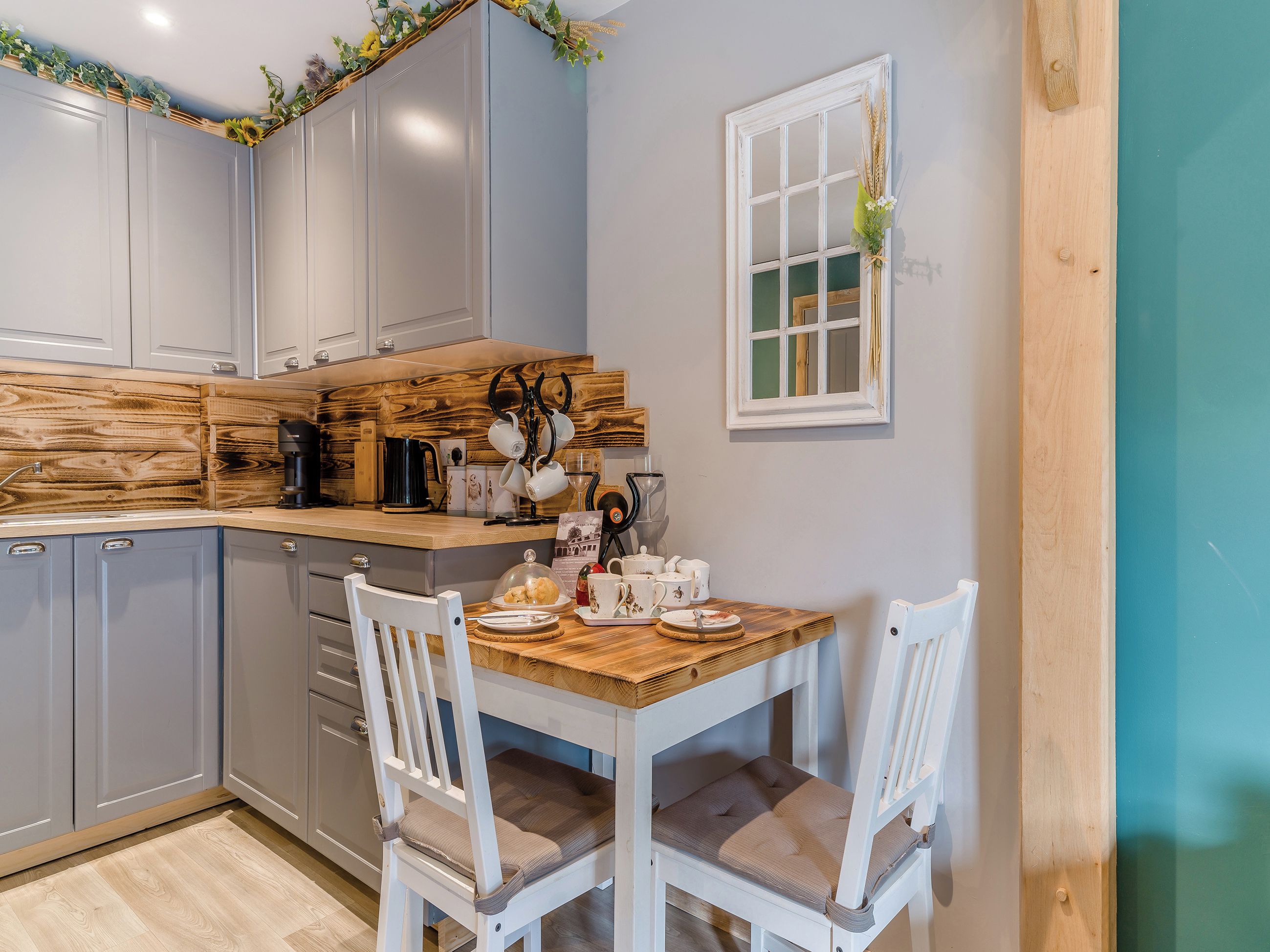 Una cocina con detalles de madera, una mesa de comedor con sillas y un ventanal con vistas.
