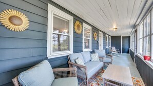 A covered porch with a sofa and chairs, sunflowers on the wall, and a table. - < 1 Mi to Lake: Mtn-View Cabin w/ Porch in Newport (Newport)
