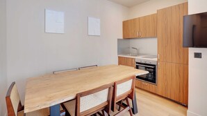 Une cuisine moderne avec des meubles en bois, un four encastré et un réfrigérateur.