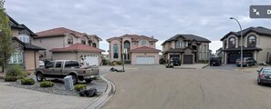 Une rue résidentielle bordée de maisons, avec un camion et une voiture.