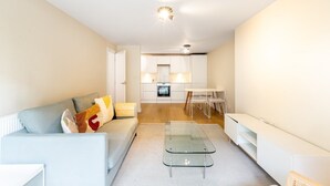 Een modern appartement met een woonkamer, een eethoek en een keuken.