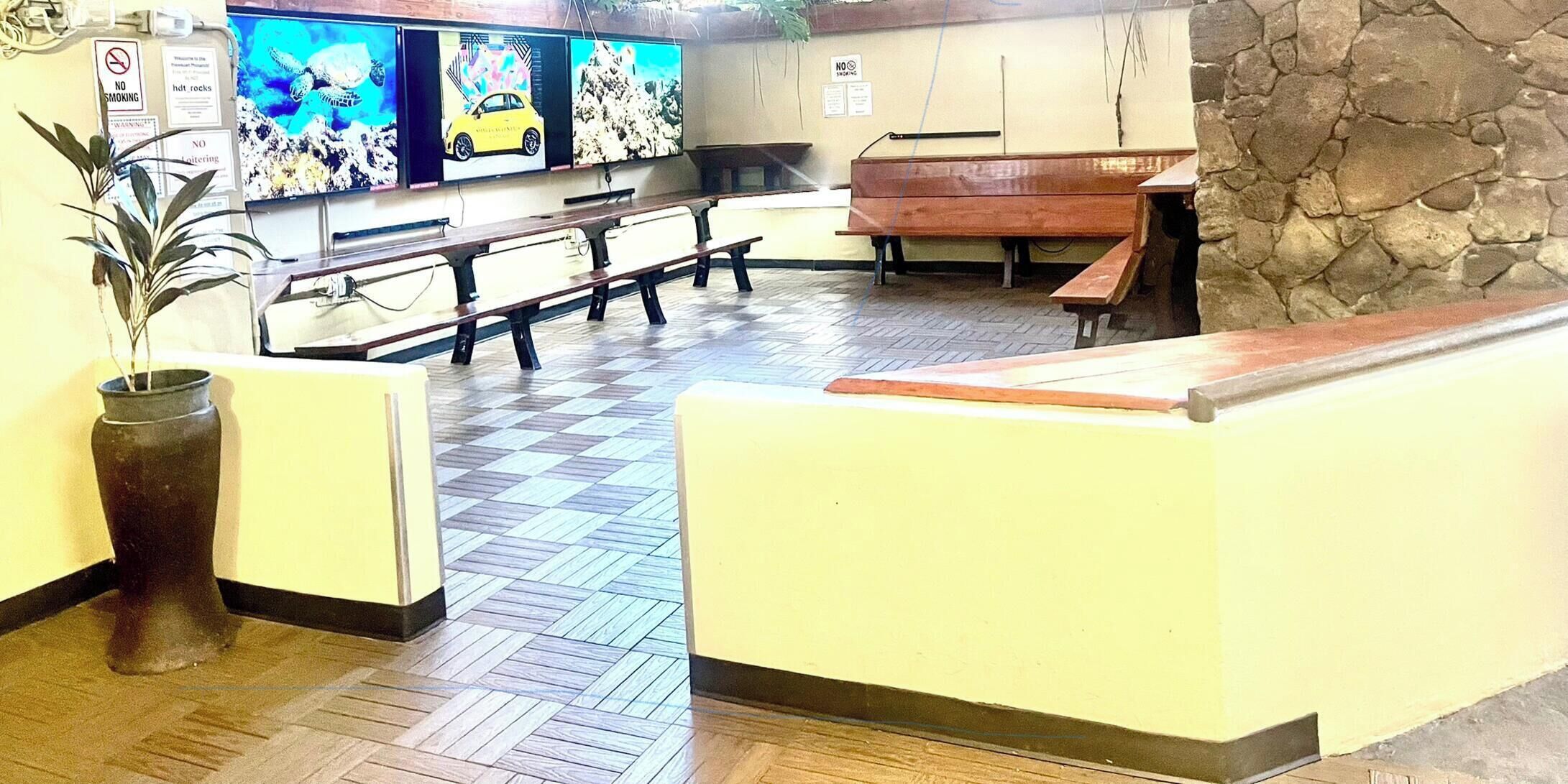 A reception area with a check-in counter, seating, and a wall-mounted TV.