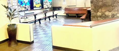 A reception area with a check-in counter, seating, and a wall-mounted TV.