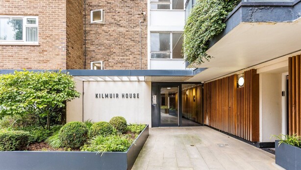 Een moderne entree van een gebouw met een bord waarop 'KILMUIR HOUSE' staat.
