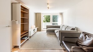 Een moderne woonkamer met een bank, een salontafel en een boekenkast.