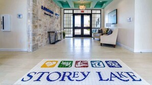 Eine Hotelhalle mit einer Rezeption, einer Sitzecke und einem 'STOREY LAKE'-Schild auf dem Boden.