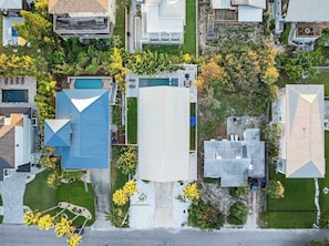 Vista aerea di una zona residenziale con case, una piscina e un ampio spazio aperto.