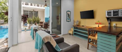Un salon moderne avec vue sur la piscine, un coin repas et une cuisine équipée d’un four à micro-ondes.