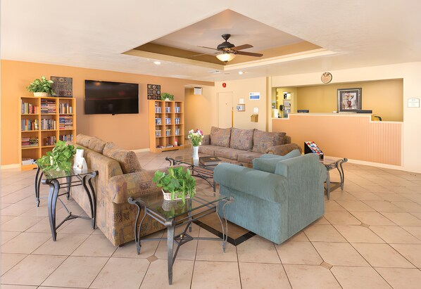 A spacious living area with multiple sofas, a coffee table, and a bookshelf.