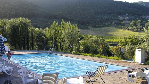 A swimming pool with lounge chairs and a view of a hilly landscape. - Charming House in Tuscany With Pool & Views (Sovicille)