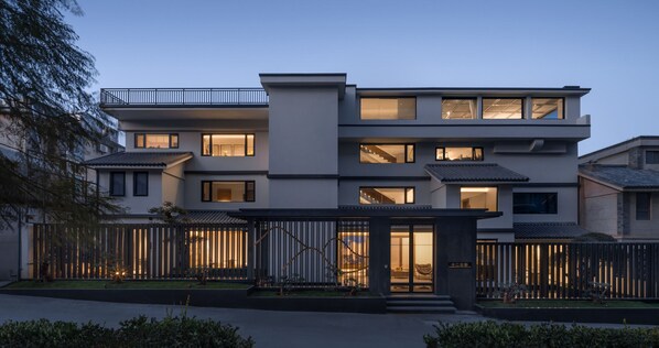 A modern multi-story residential building with a balcony, large windows, and a well-lit entrance. - Dali Puyu VILLA Cliff Seaview Hotel (Dali)