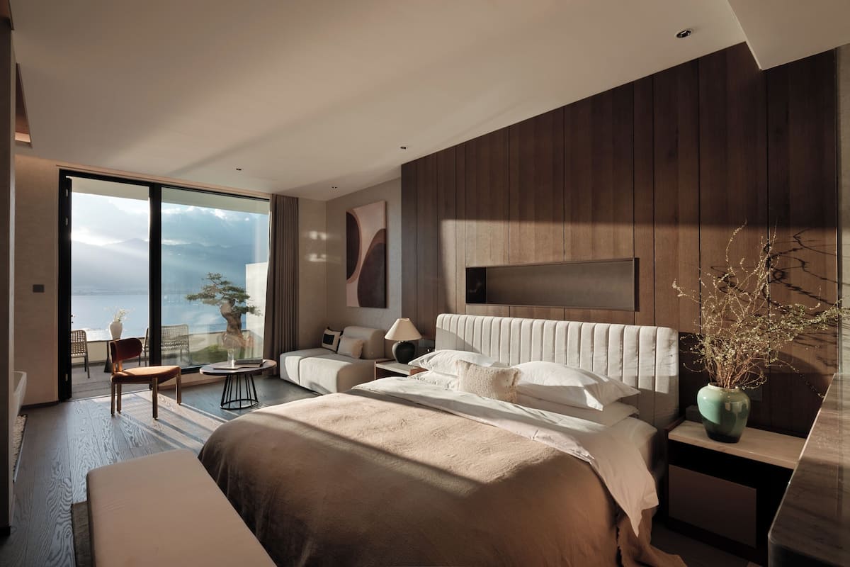 Une chambre moderne dotée d’un grand lit, d’un coin salon et offrant une vue sur les montagnes.