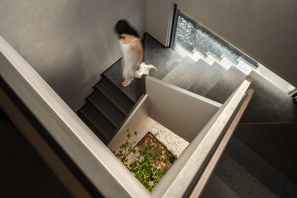 A modern staircase with a small garden area at the bottom.
