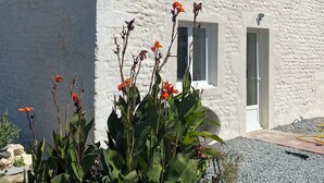 A white building with a stone facade, multiple windows, and a door. - Between land and sea (Marennes-Hiers-Brouage)